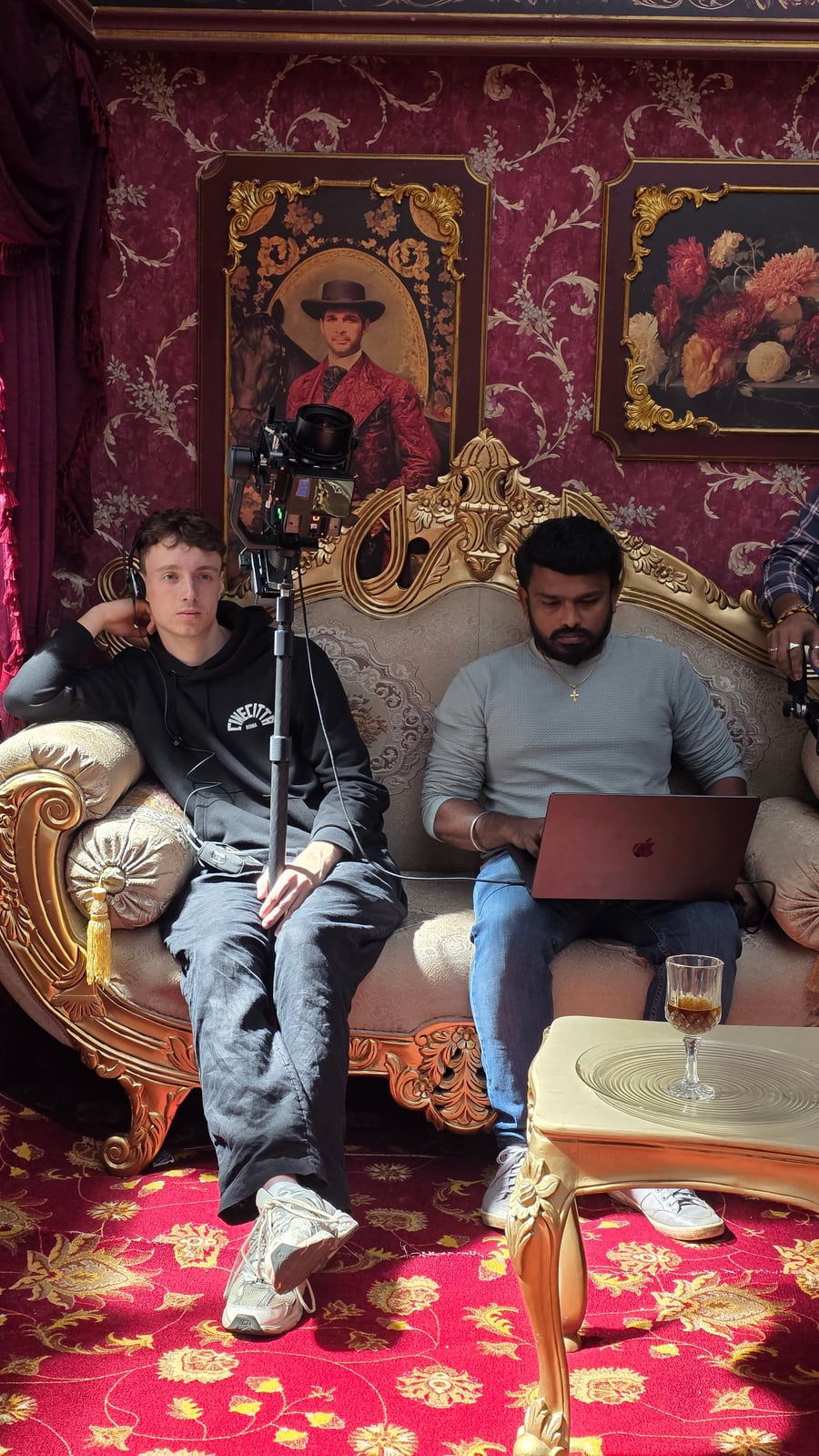 Hyper-WarpCam® camera on its pole beside seated crew members in an ornate interior set.