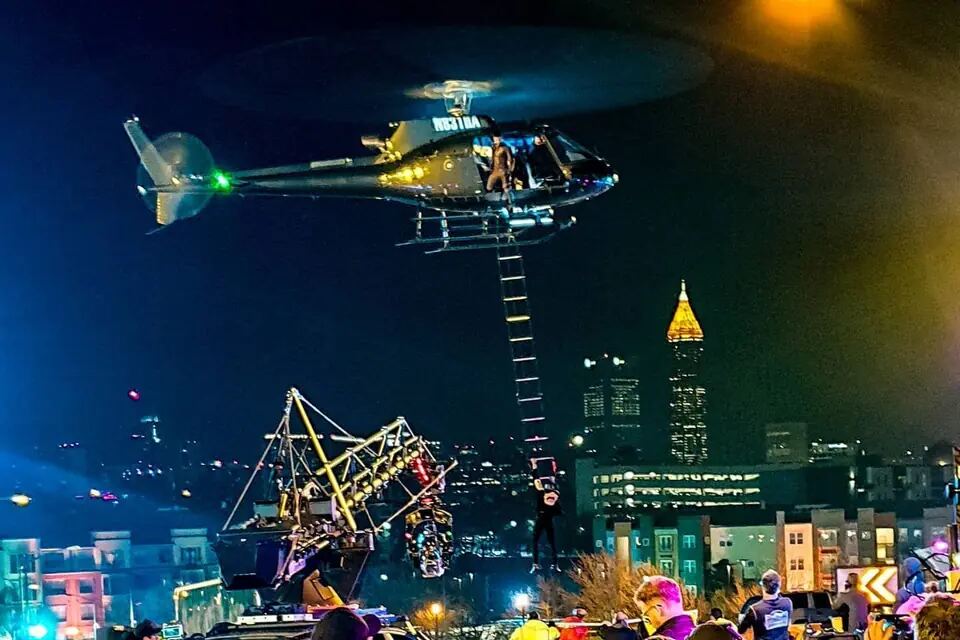 Performer hangs beneath a helicopter during a night action sequence for Bad Boys for Life